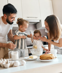 parents smearing their daughter's nose with flour